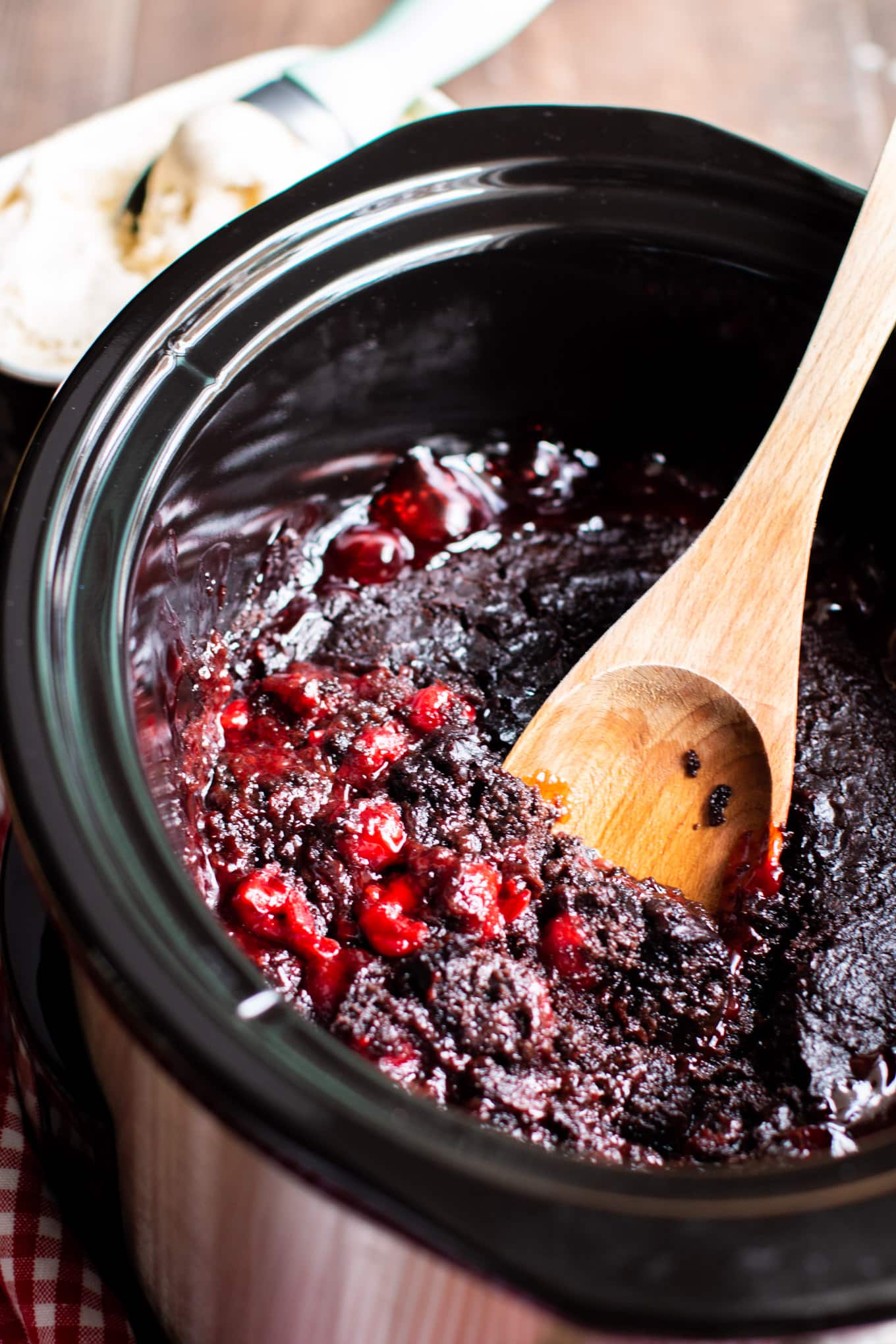 close up of cherry chocolate cake with spoon in it.