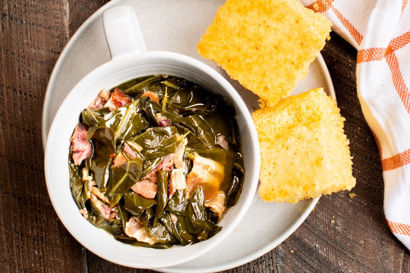 Collard green in bowl with cornbread on the side