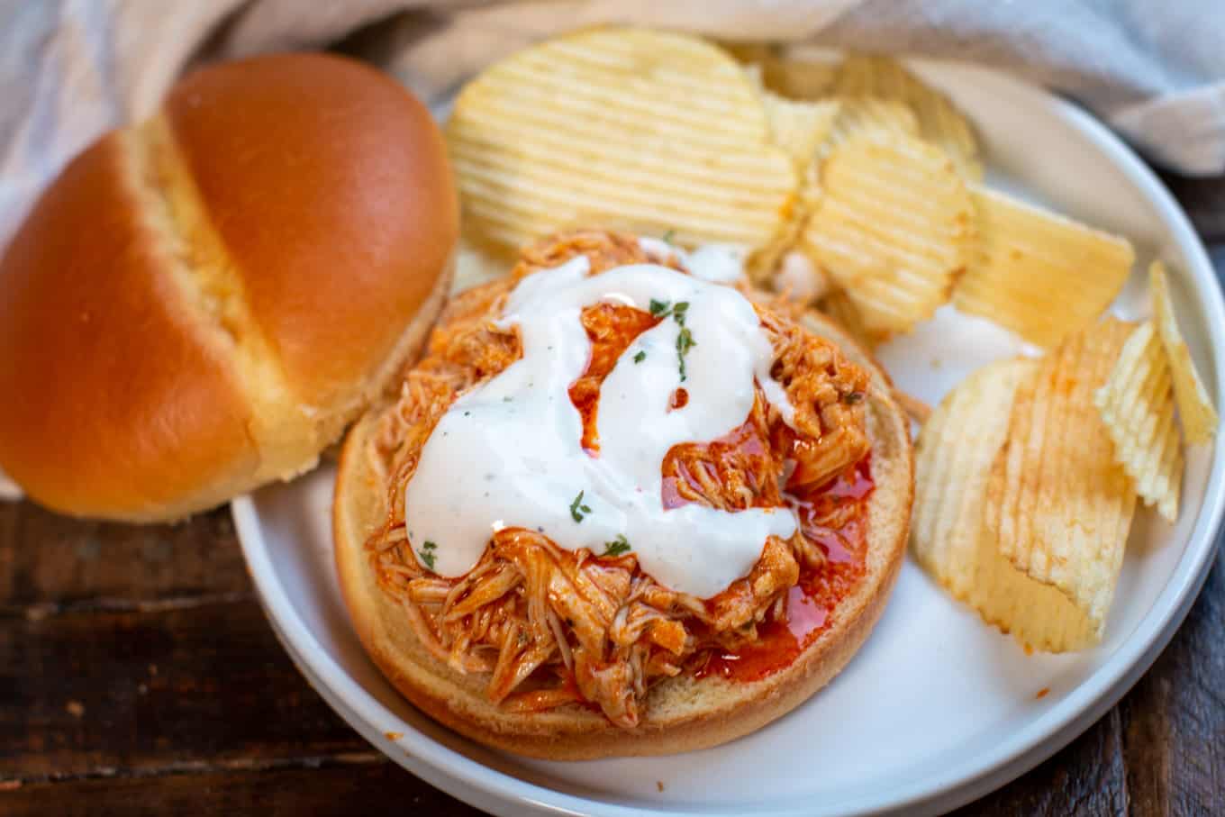 shredded buffalo chicken on bun with ranch and chips