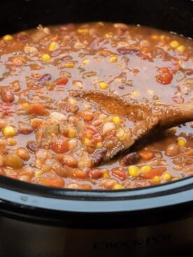 spoon in bean soup in slow cooker
