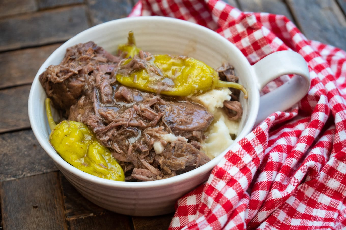 Mashed potatoes in bowl with shredded meat on top