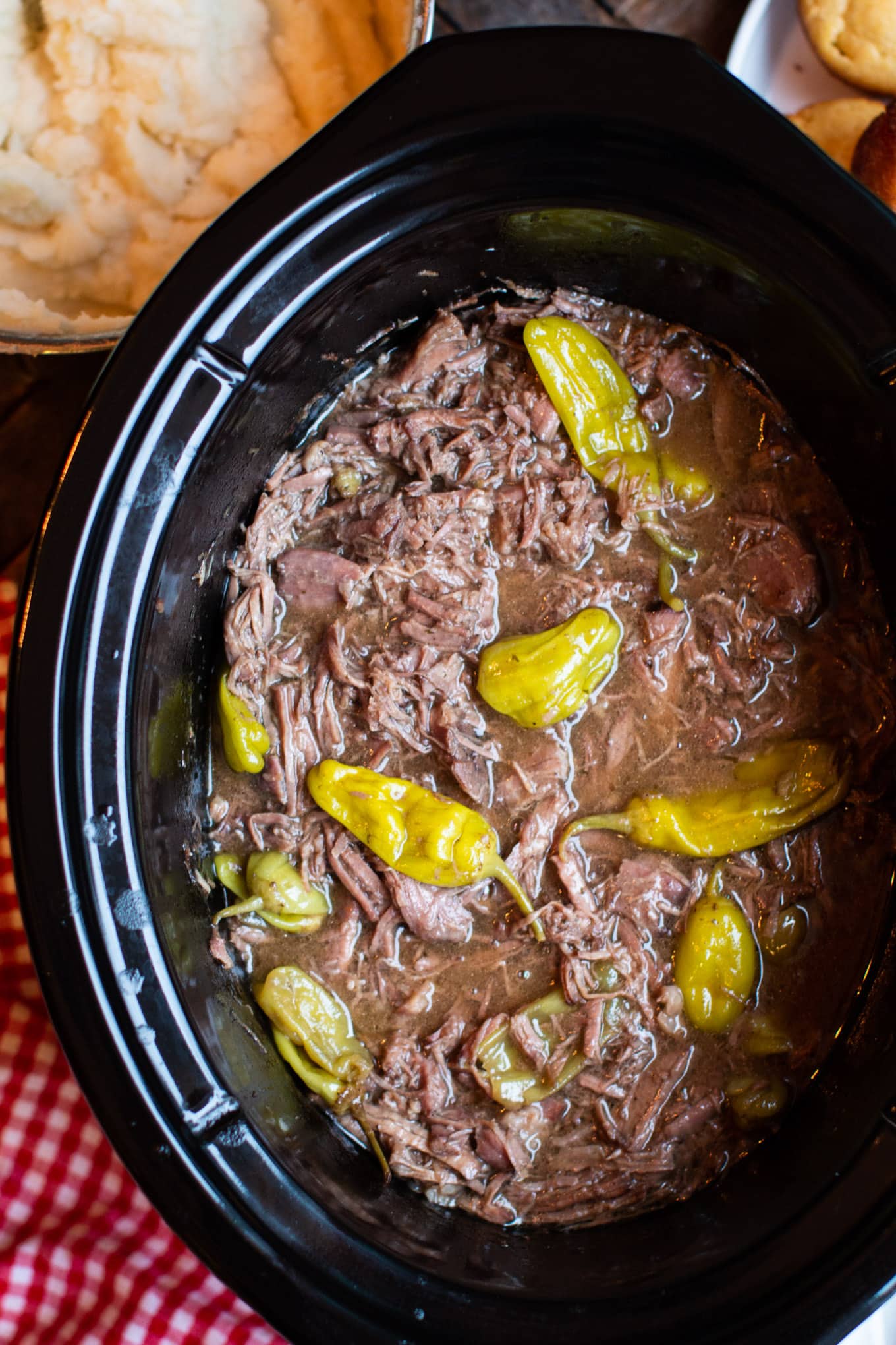 cooked pot roast with peppers in slow cooker.