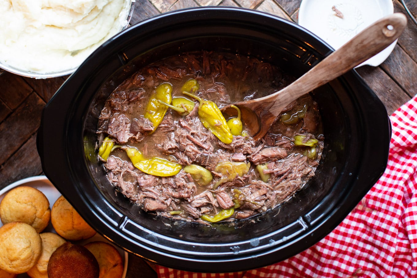 shredded mississippi pot roast ready to serve with a wooden spoon