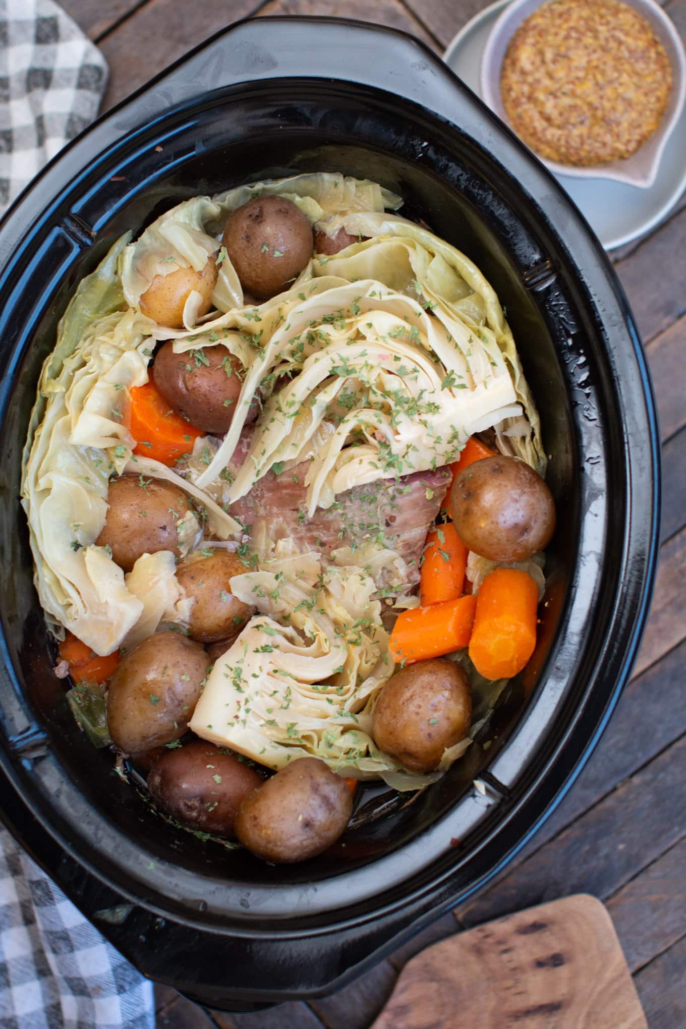 cooked corned beef, potatoes, cabbage and carrots in slow cooker.