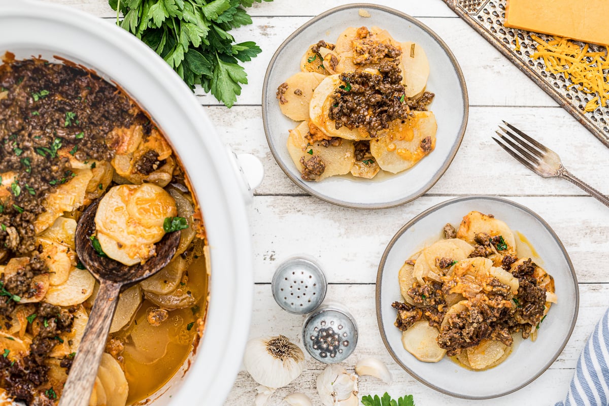 overhead shot of beef gratin in slow cooker and on plates.