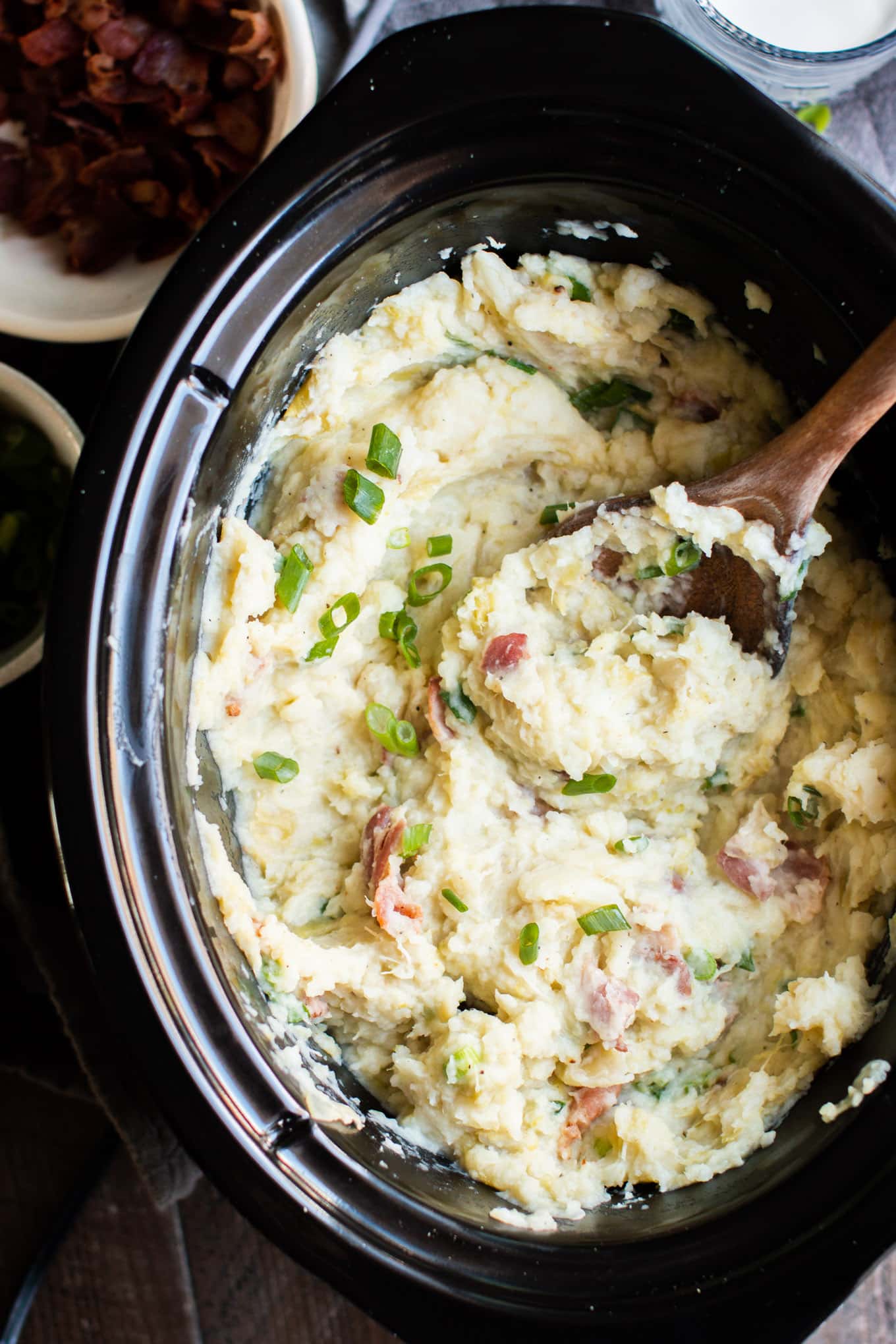 Colcannon potatoes with green onions on top. With wooden spoon in them.