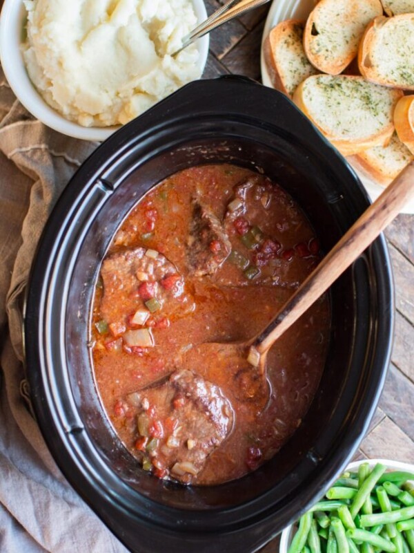 Cooked swiss steak with wooden spatula.