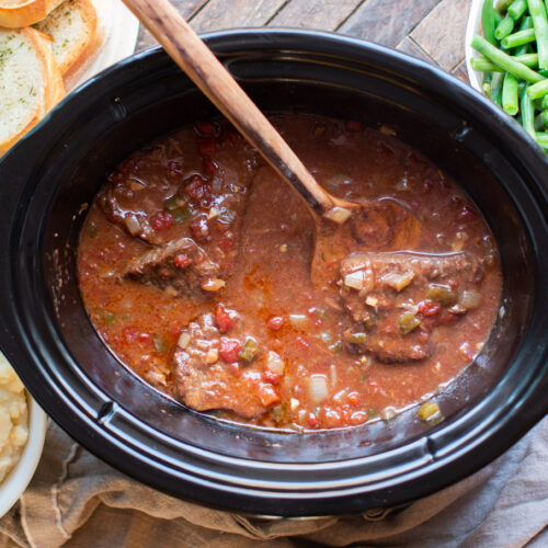finished swiss steak in crockpt with serving spatula