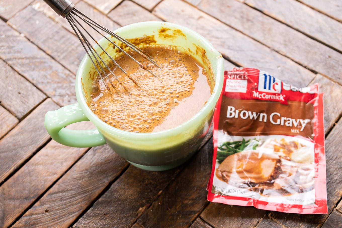 brown gravy mix packets next to bowl of prepared gravy