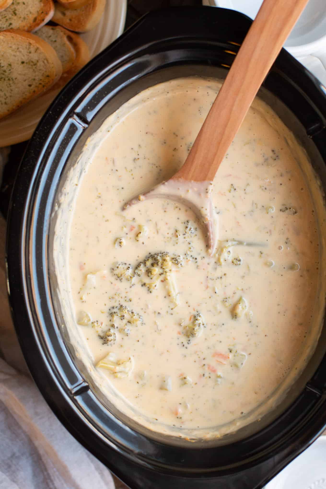 cooked broccoli cheese soup in slow cooker with spoon