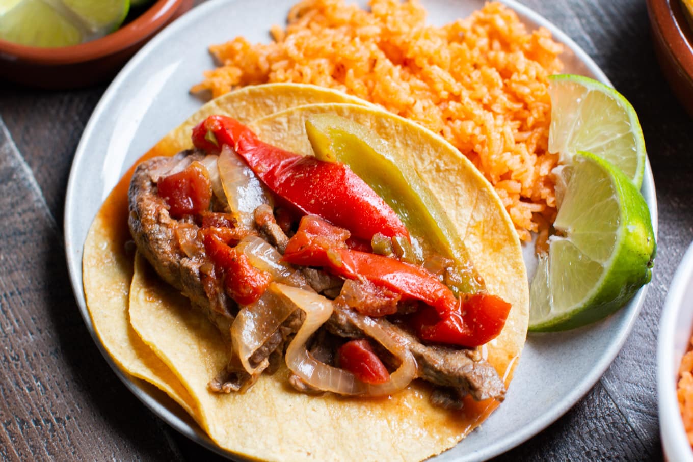 extra close up photo of beef fajitas on corn tortillas