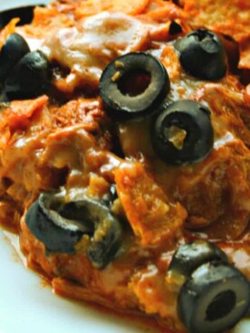 chicken dorito casserole in white bowl with olives on top