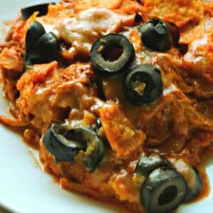chicken dorito casserole in white bowl with olives on top