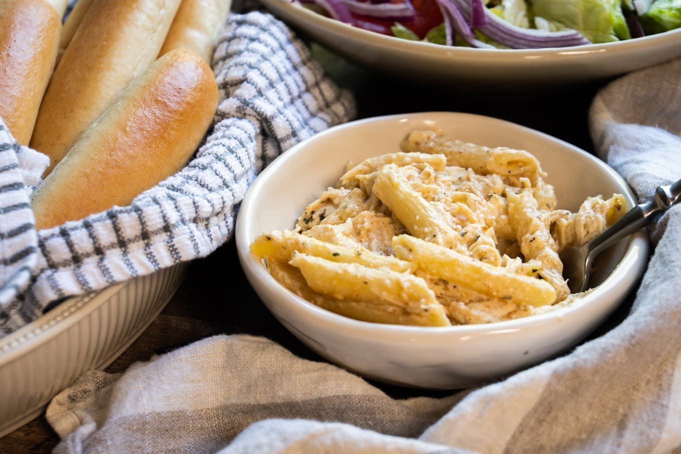 chicken penne pasta in white bowl