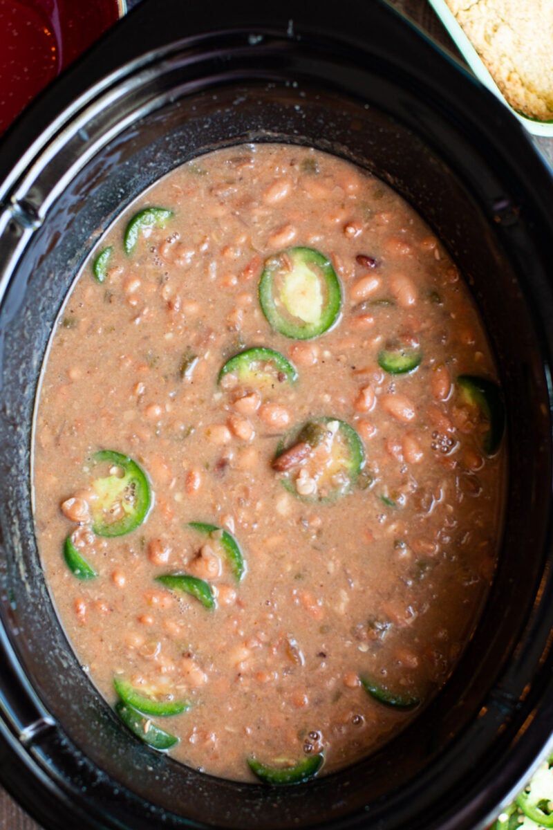 close up of spicy pinto beans with jalapenos on top.