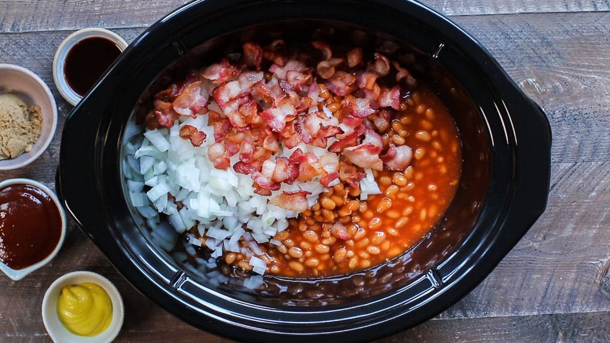 baked beans, halfway cooked bacon, onion in slow cooker unstirred.