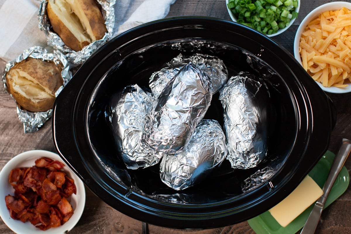 cooked baked potatoes in foil in slow cooker
