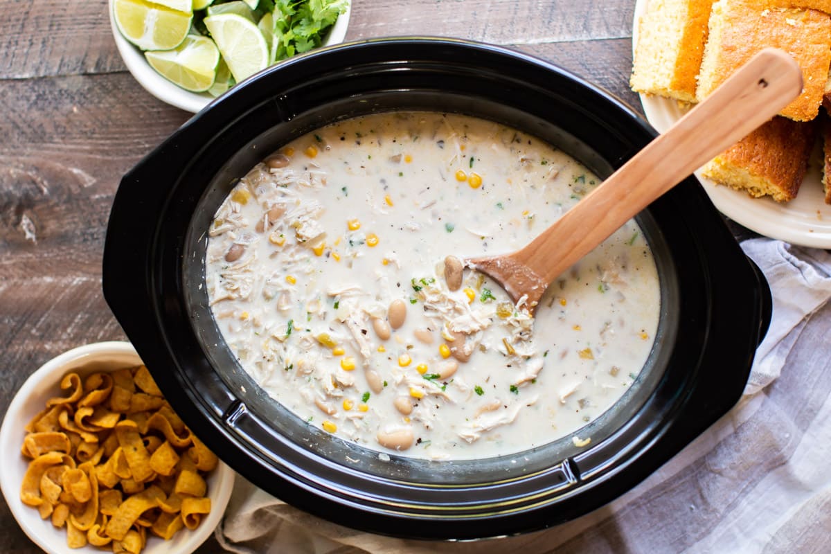 white chili with chicken and corn with fritos and cornbread on the side