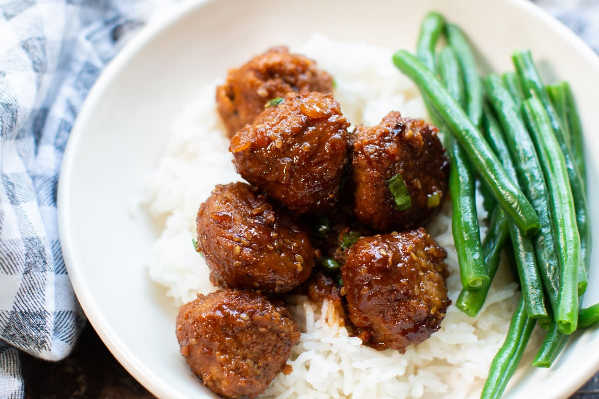 bowl of rice with teriyaki meatballs on top.