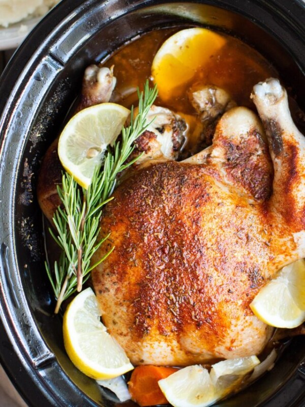Whole chicken done cooking in the slow cooker with dried thyme.