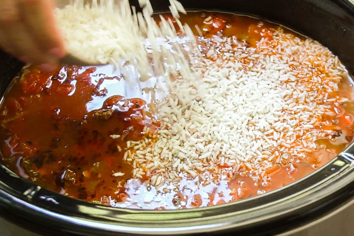 Minute rice being sprinkled over hot soup