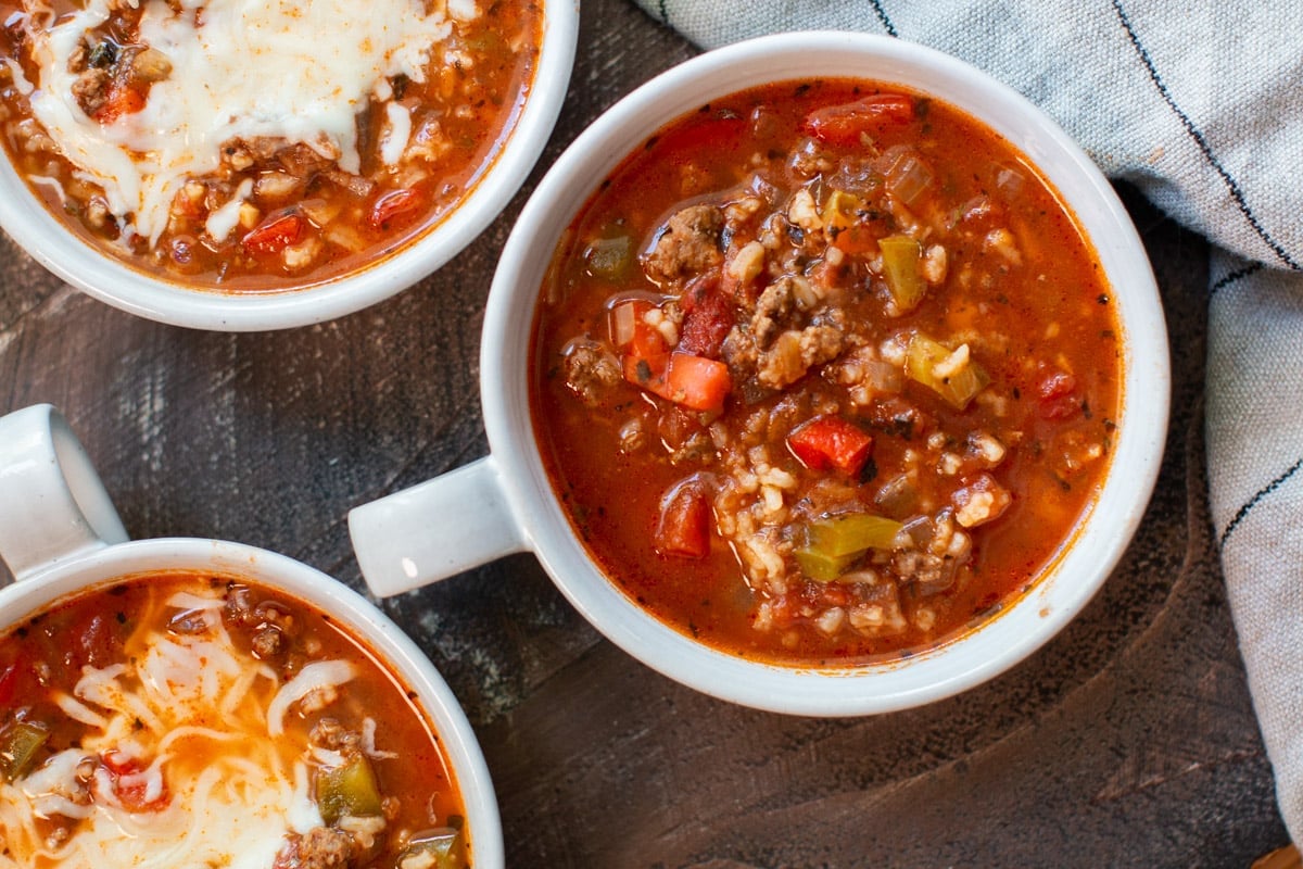 3 bowls of stuffed peppers soup. 2 with cheese on top.