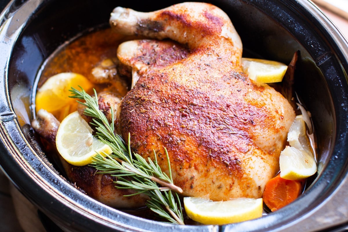 whole cooked chicken in a slow cooker with lemons