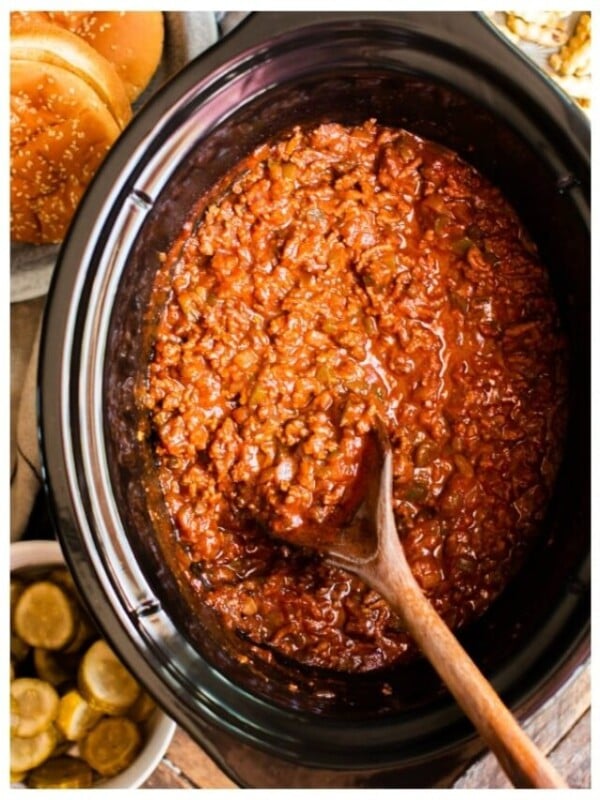 cooked sloppy joe meat in a slow cooker with a spoon in it.