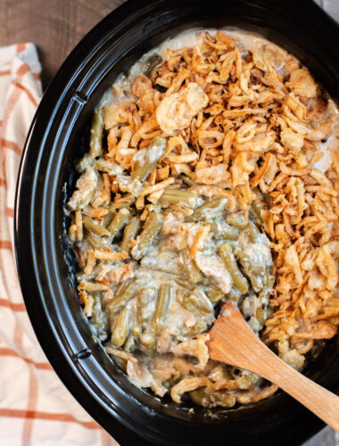 close up of green bean casserole with a spoon in it.