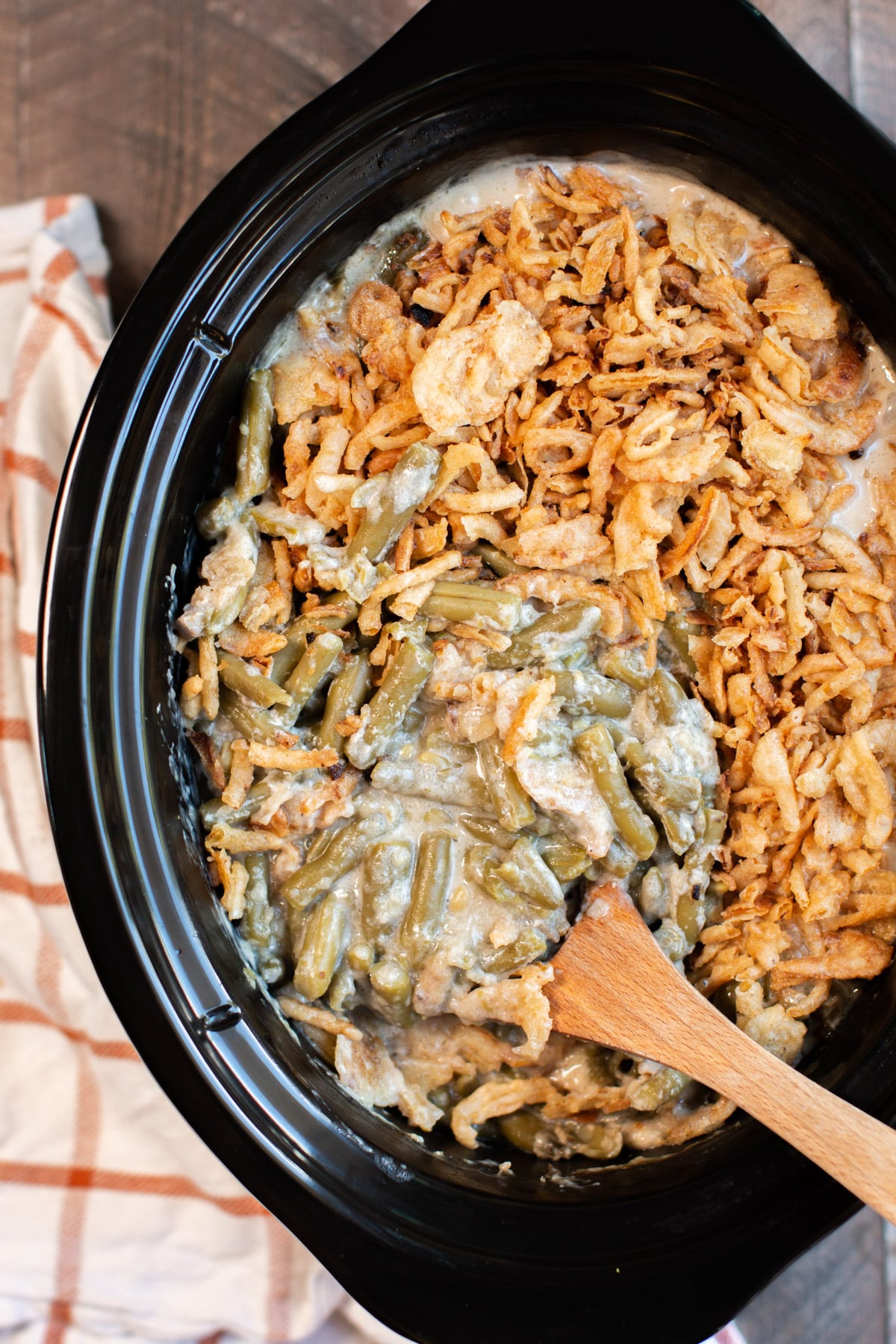 close up of green bean casserole with a spoon in it.