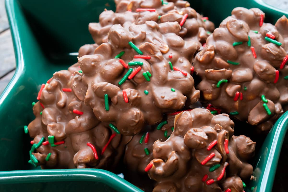 green bowl full of peanut clusters with red and green sprinkles