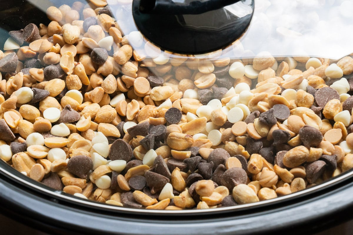 lid on slow cooker with peanuts and chocolate chips in it