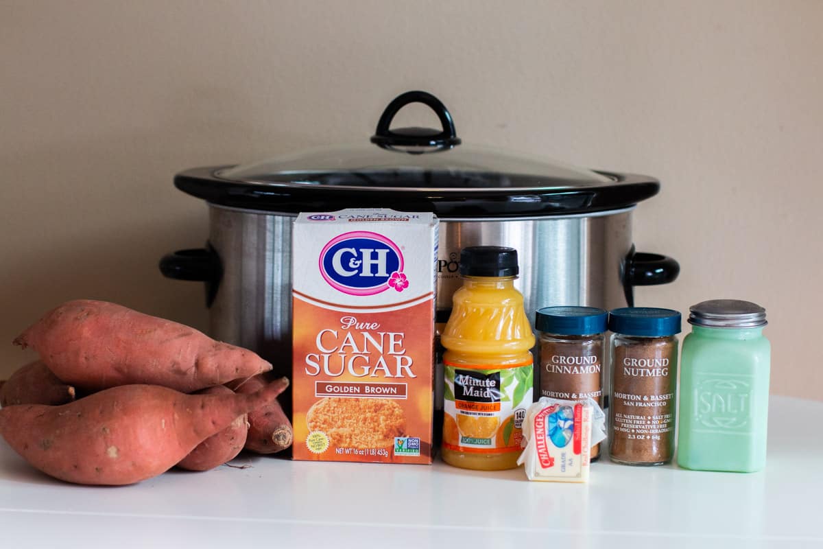 sweet potatoes, brown sugar, nutmeg, cinnamon, salt, orange juice and butter in front of slow cooker