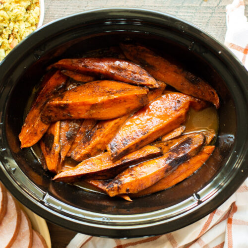 sweet potato wedges done cooking in slow cooker with cinnamon on top.