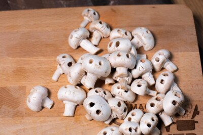 whole mushrooms with skull faces cut into them