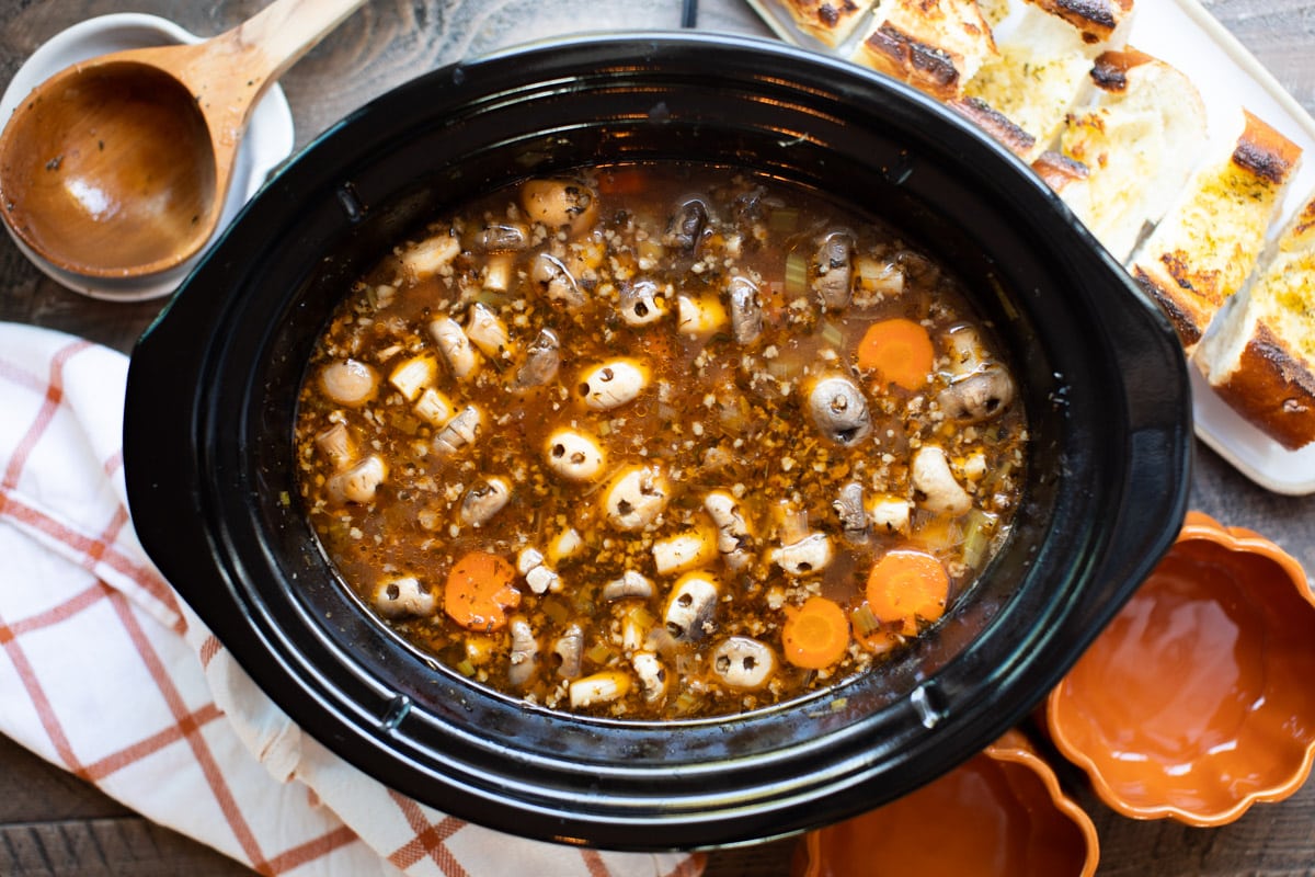 slow cooker full of stew with ground beef, carrots and mushrooms