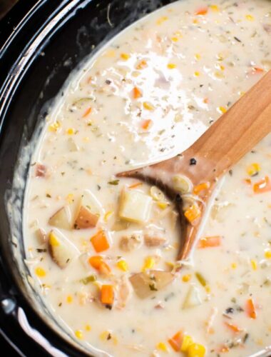 cooked turkey chowder in a slow cooker with a wooden spoon.