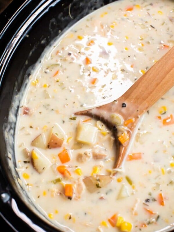 cooked turkey chowder in a slow cooker with a wooden spoon.