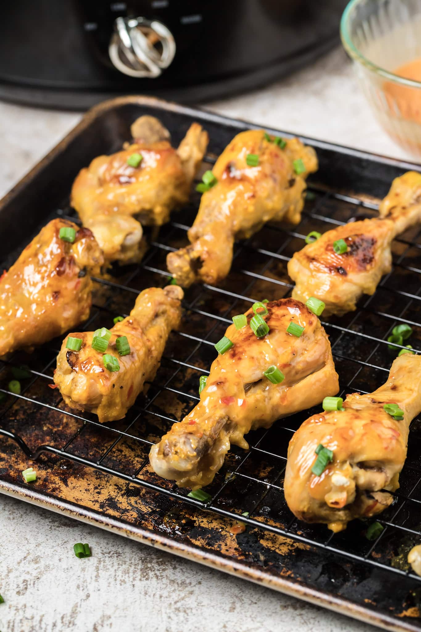 bang bang chicken on sheet pan, browned with green onions on top.