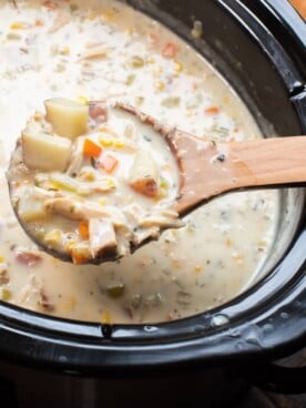 wooden spoon scooping turkey chowder out of slow cooker