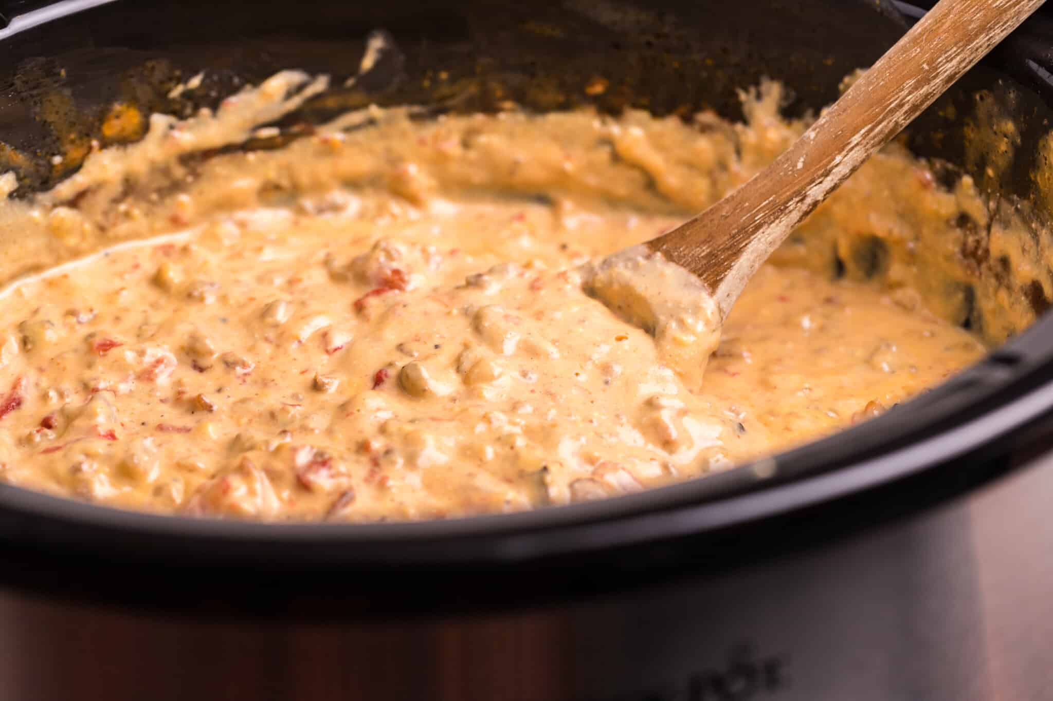 cheeseburger dip, done cooking with wooden spoon in it.