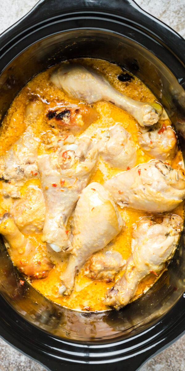 close up image of chicken with bang bang sauce in slow cooker