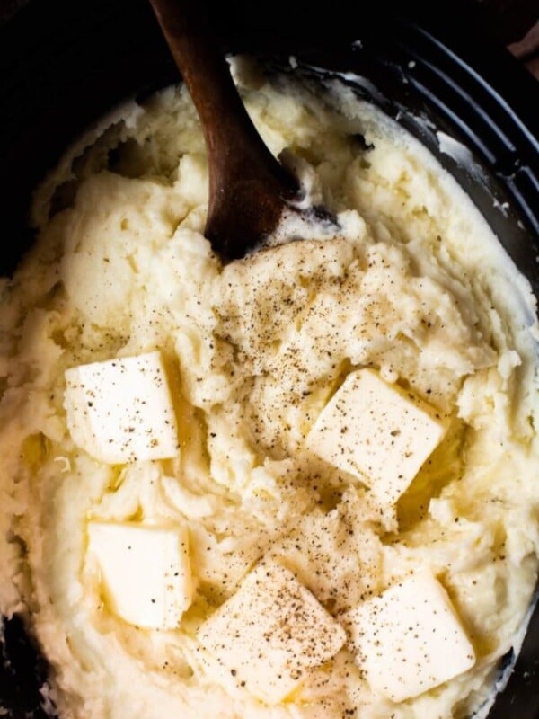 Cooked mashed potatoes with butter slices on top.
