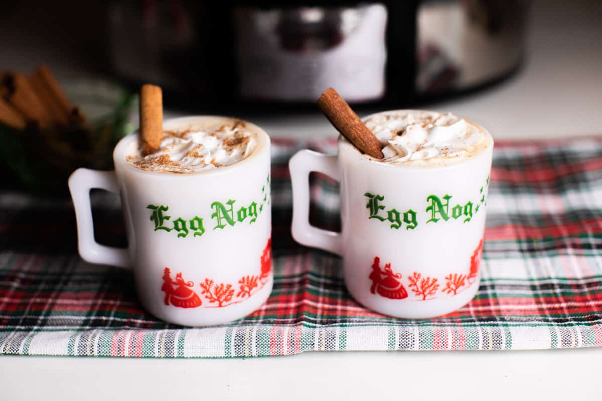 2 white mugs that say egg nog on them