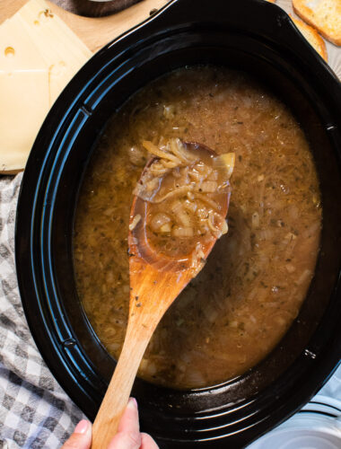 close up of french onion soup on wooden spon