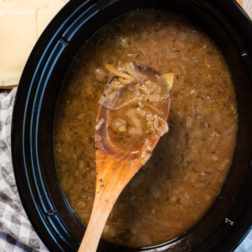 close up of french onion soup on wooden spon