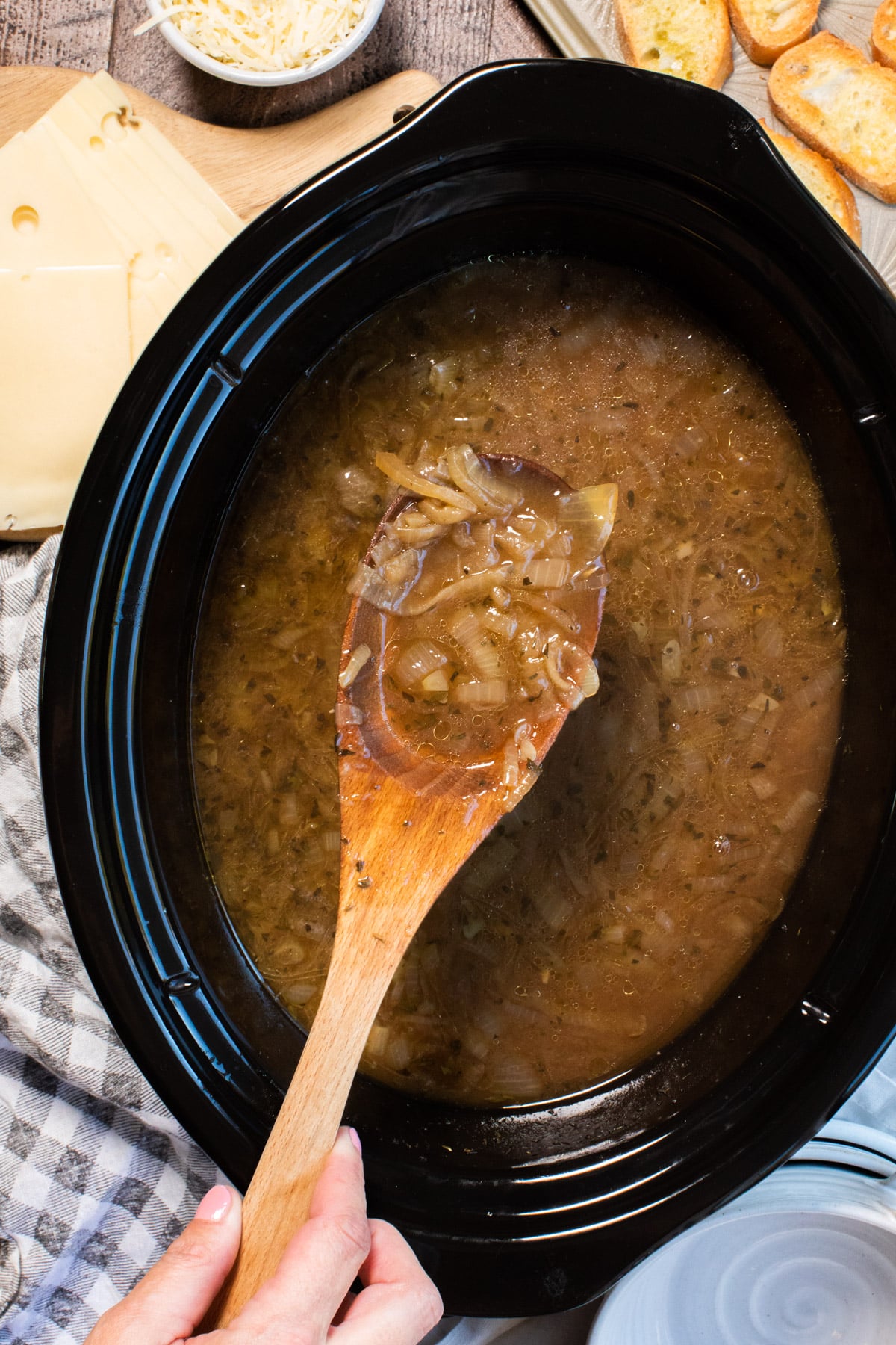 close up of french onion soup on wooden spon