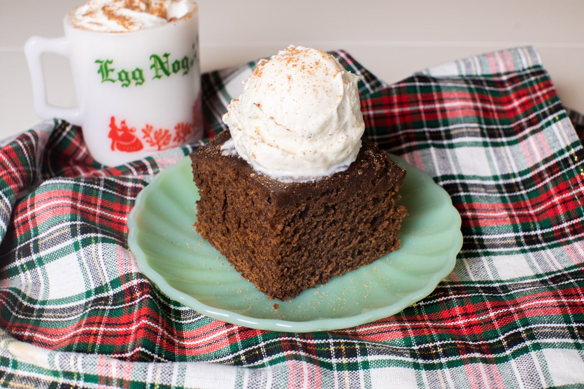 slice of gingerbread cake on plate with a scoop of ice cream