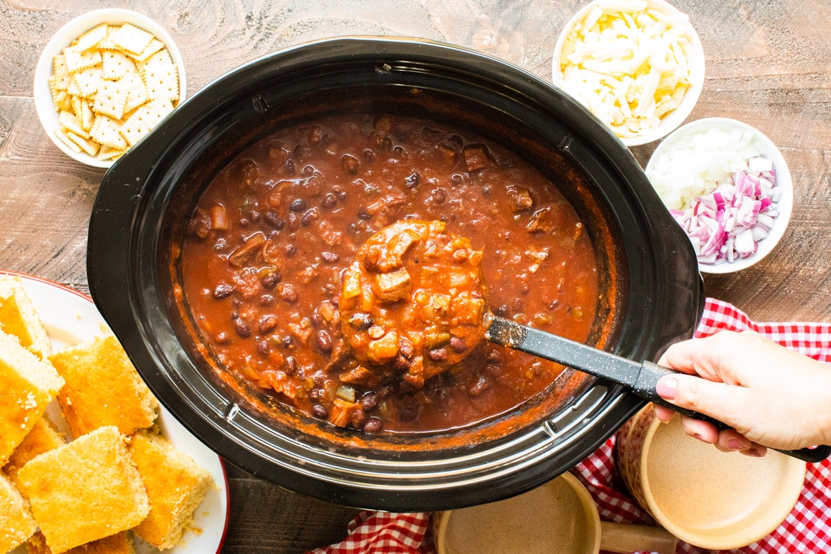 prime rib chili being scooped out of slow cooker