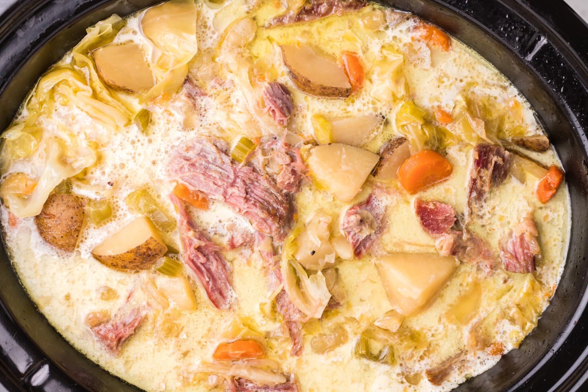 finished cooking corned beef and cabbage soup in a slow cooker